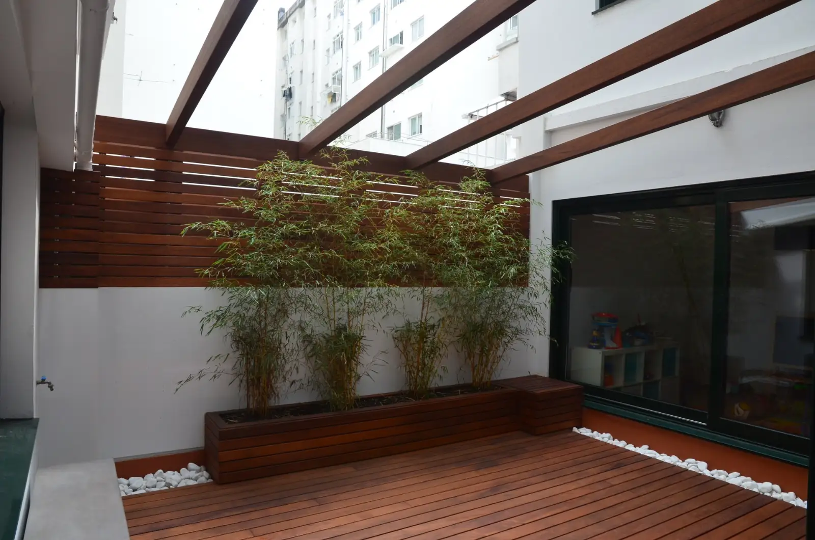 Construcción de terraza con tarima de madera, pérgola estructural y jardinera de bambú en Madrid