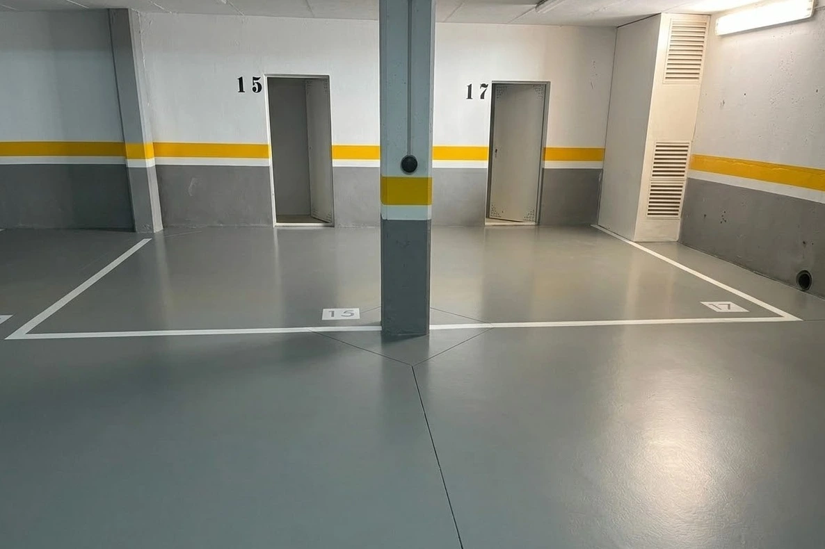 Trabajo de pintura en garaje con suelo de resina epoxi gris y señalización blanca en Madrid