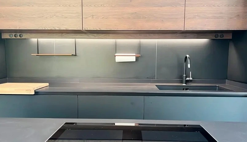 Reforma cocina con encimera negra mate, armarios de madera y fregadero integrado en Madrid