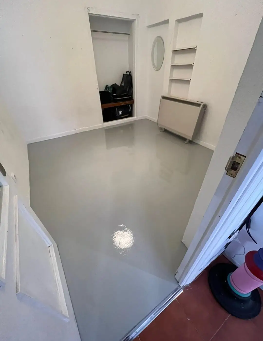 Reforma parcial con aplicación de suelo de resina gris brillante en una habitación de Madrid