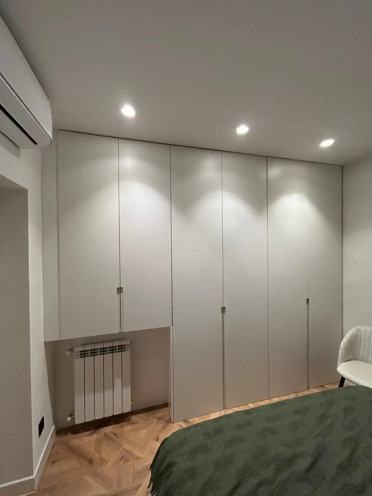 Reforma de vivienda con armario empotrado blanco a medida y suelo de parqué en Madrid