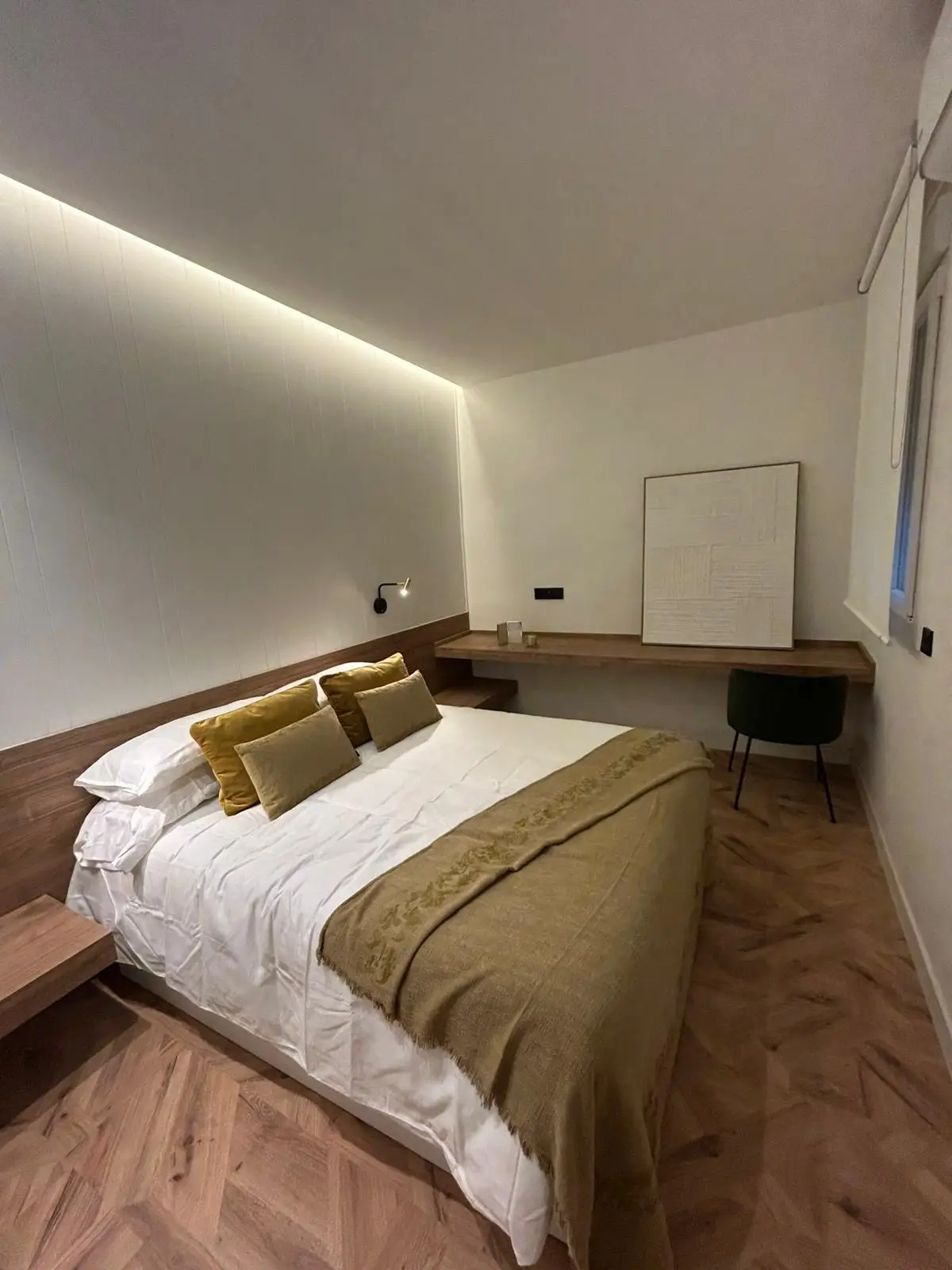 Reforma de vivienda con dormitorio principal, iluminación LED indirecta en el techo y suelo laminado en Madrid