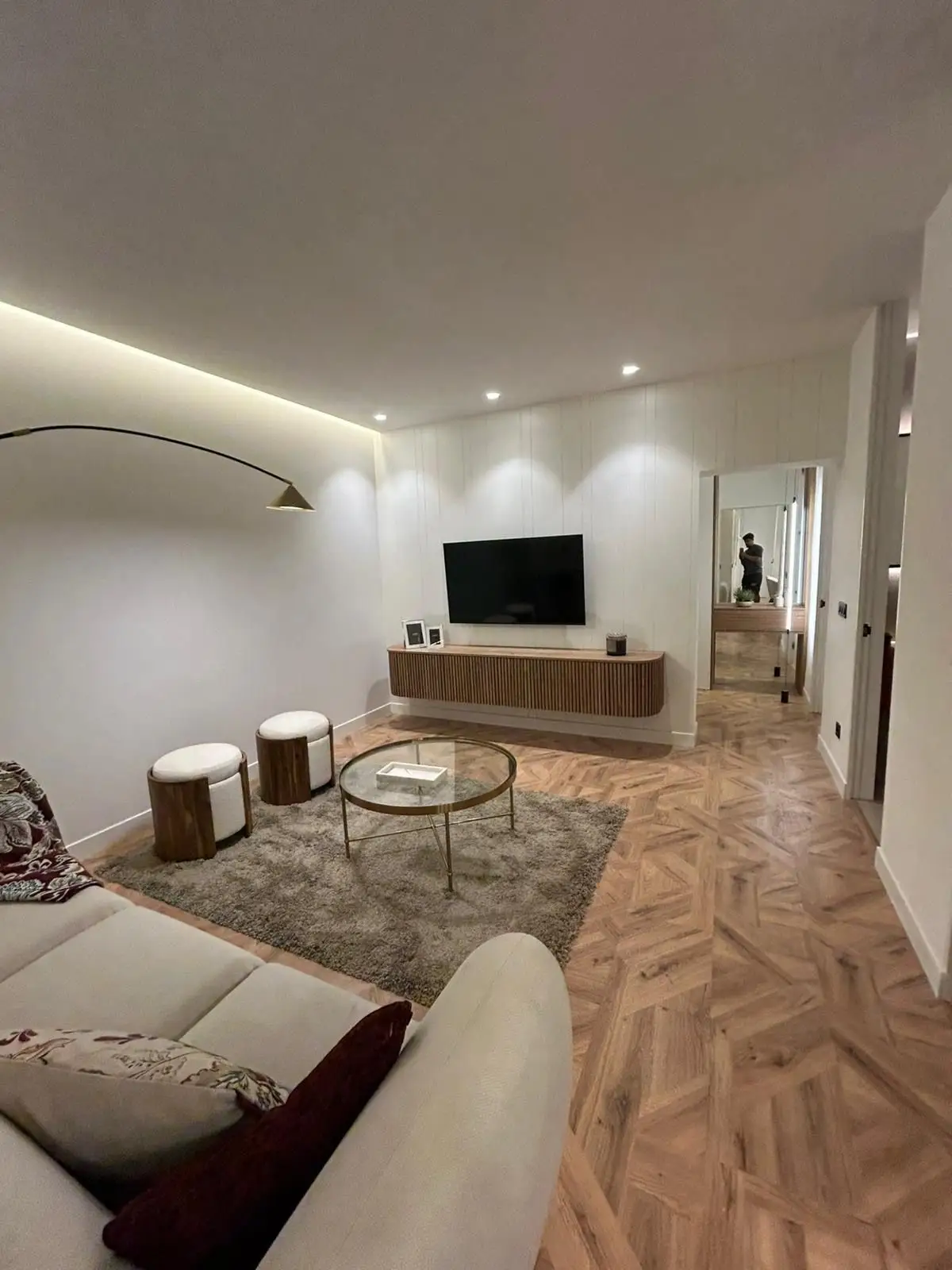 Reforma de vivienda con cabecero de madera integrado, iluminación LED indirecta y lámparas colgantes en Madrid